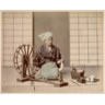 Femme filant de la soie avec un rouet